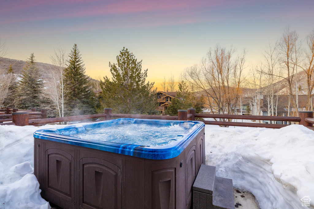 Pool at dusk with a hot tub