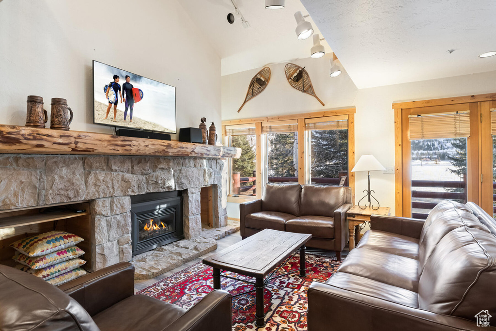 Living room with a fireplace and high vaulted ceiling