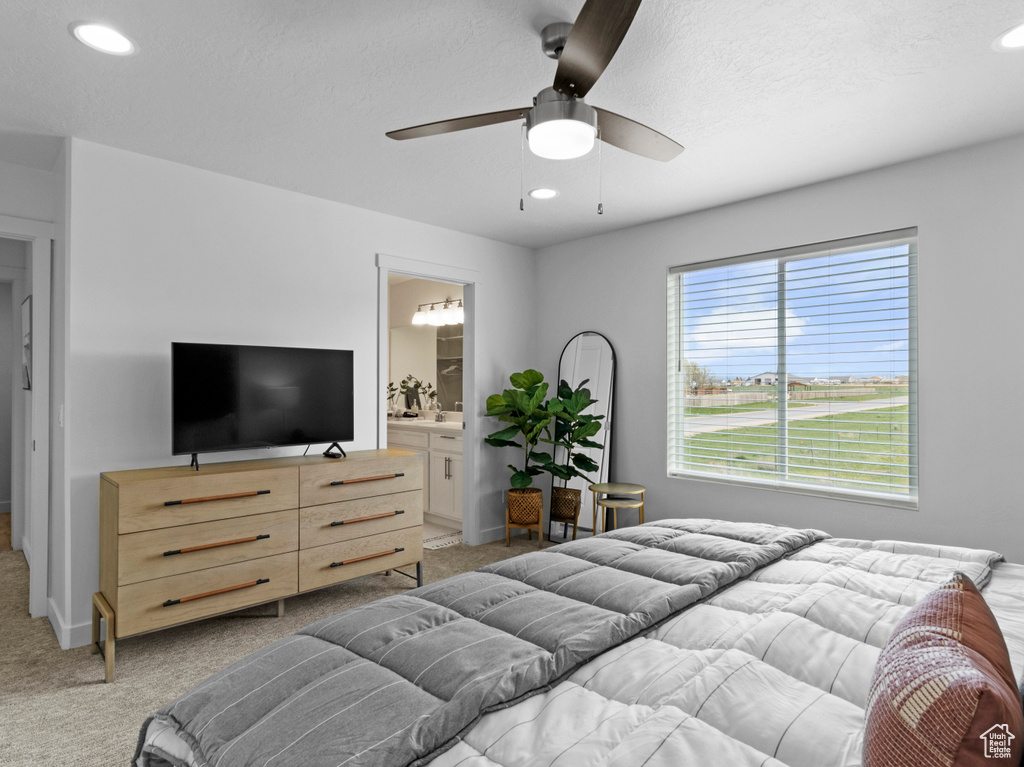 Bedroom featuring ensuite bathroom, light colored carpet, and ceiling fan