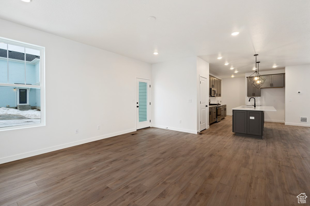 Unfurnished living room with sink and dark hardwood / wood-style floors