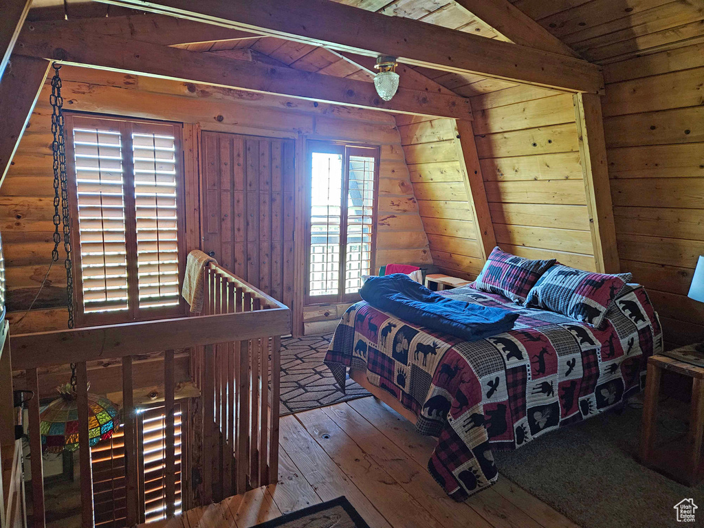 Bedroom featuring lofted ceiling with beams, wood ceiling, and hardwood / wood-style floors