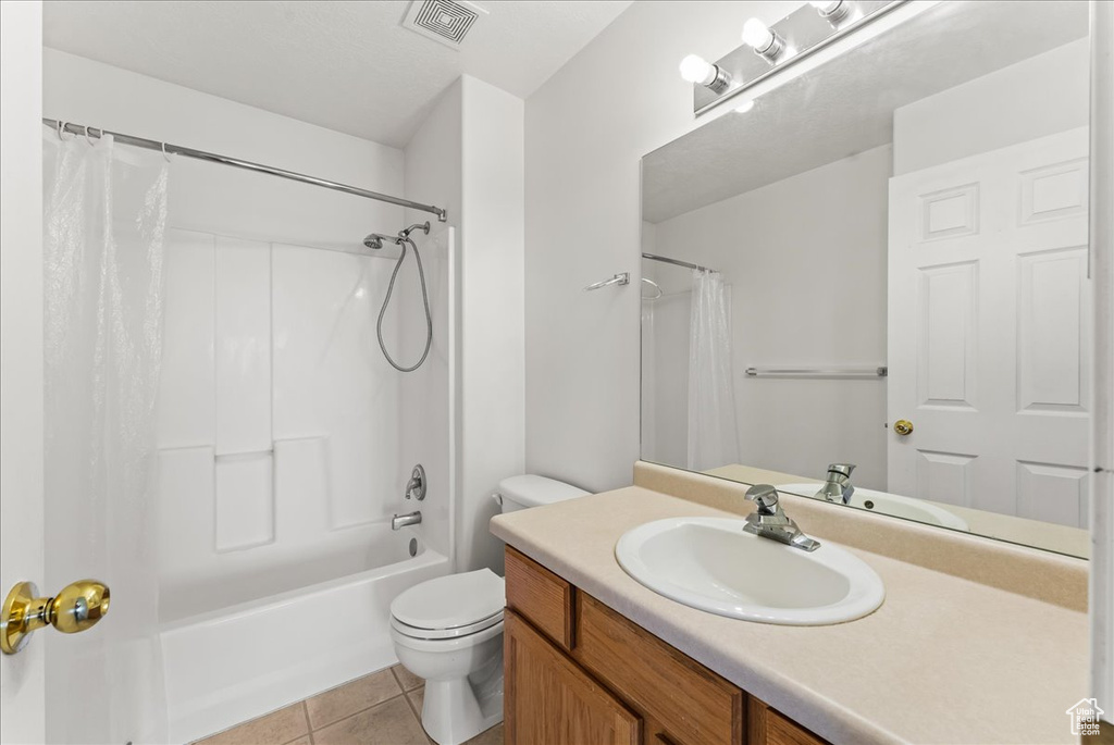 Full bathroom featuring shower / tub combo with curtain, toilet, tile flooring, and oversized vanity