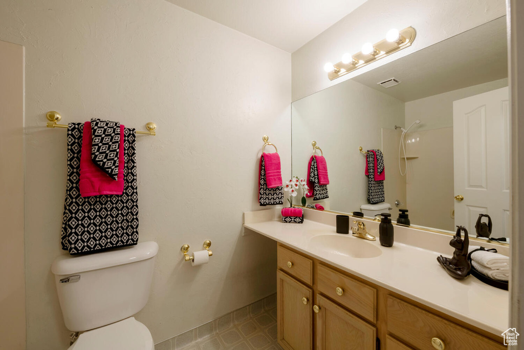 Bathroom featuring large vanity, toilet, and tile floors
