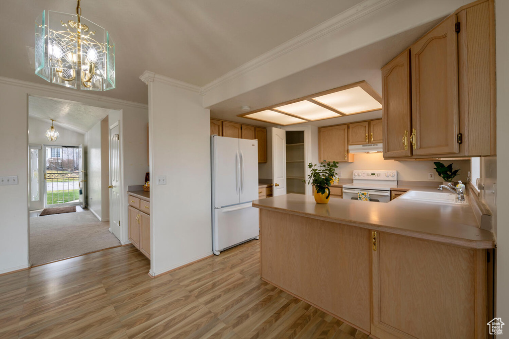 Kitchen featuring range, white fridge, light colored carpet, pendant lighting, and sink