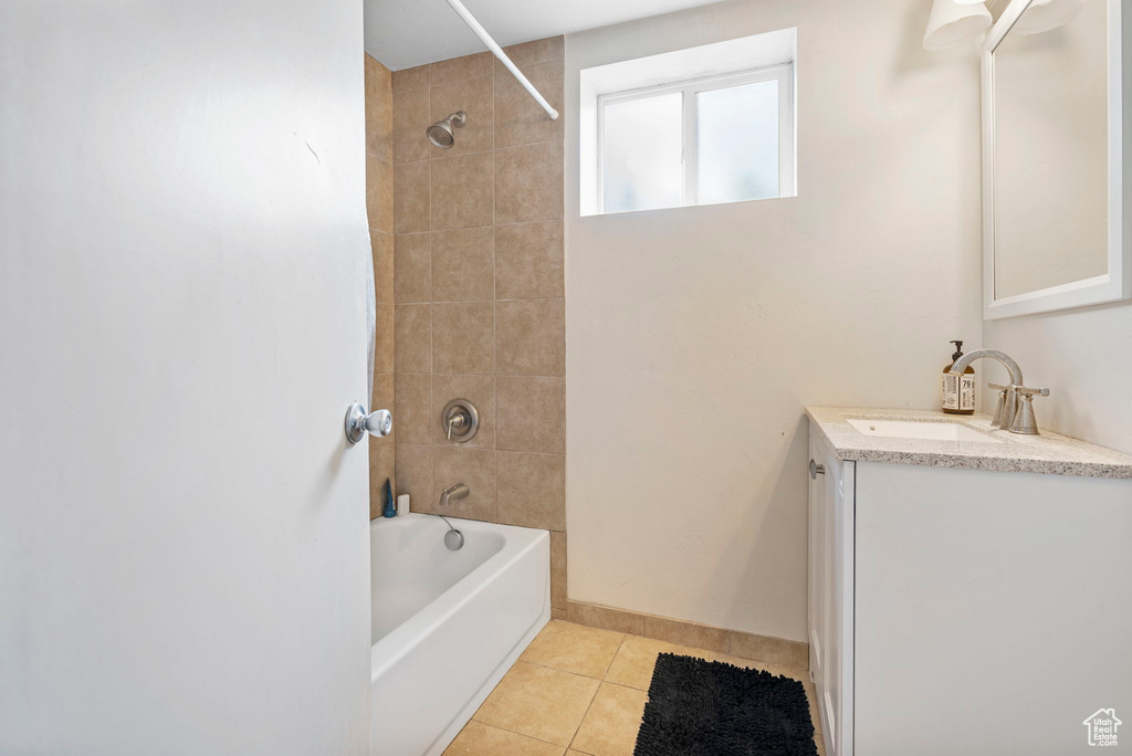 Bathroom with tile flooring, vanity, and tiled shower / bath combo