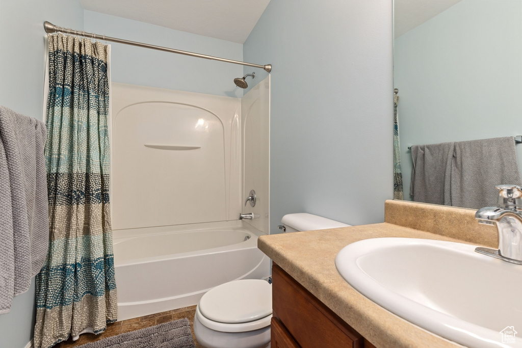 Full bathroom featuring vanity, shower / tub combo with curtain, and toilet