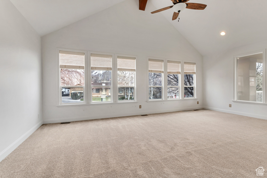 Unfurnished room featuring high vaulted ceiling, light carpet, and ceiling fan