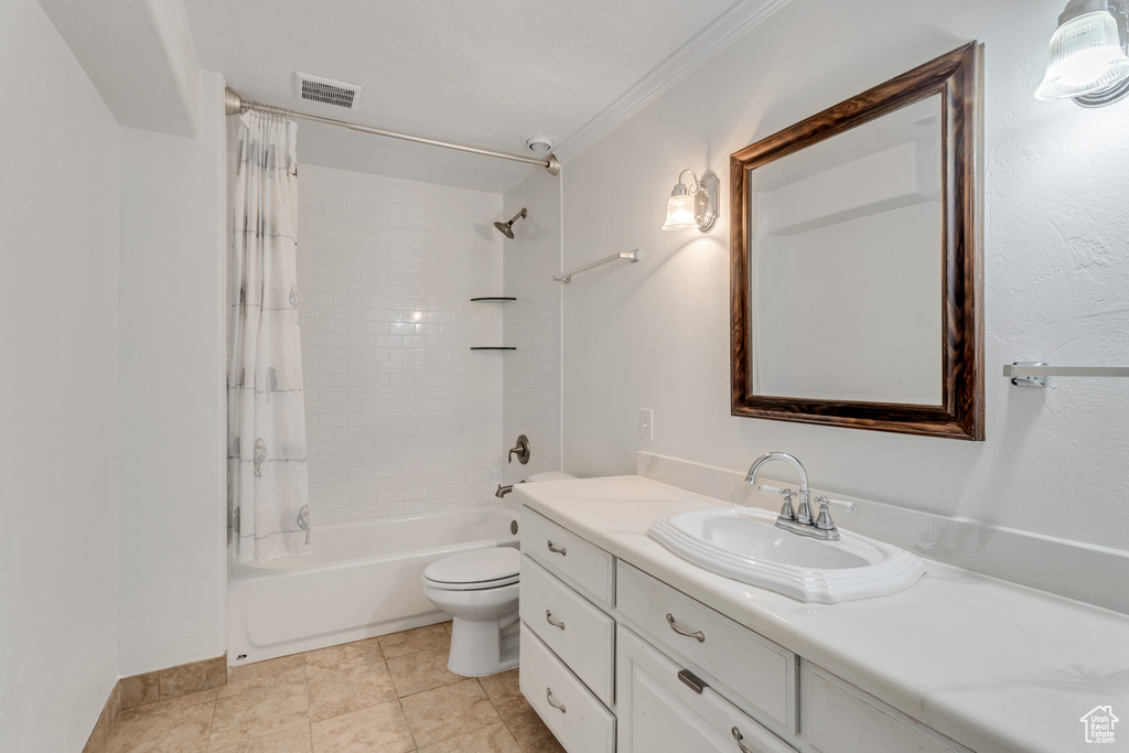 Full bathroom featuring vanity, ornamental molding, tile flooring, shower / bath combo with shower curtain, and toilet