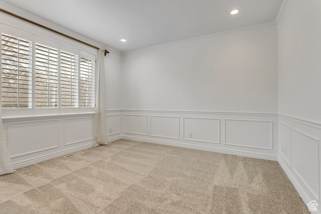 Carpeted spare room featuring crown molding