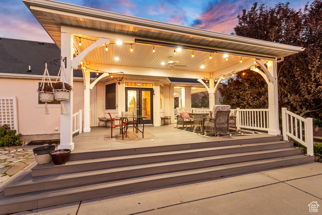 Patio terrace at dusk featuring a wooden deck