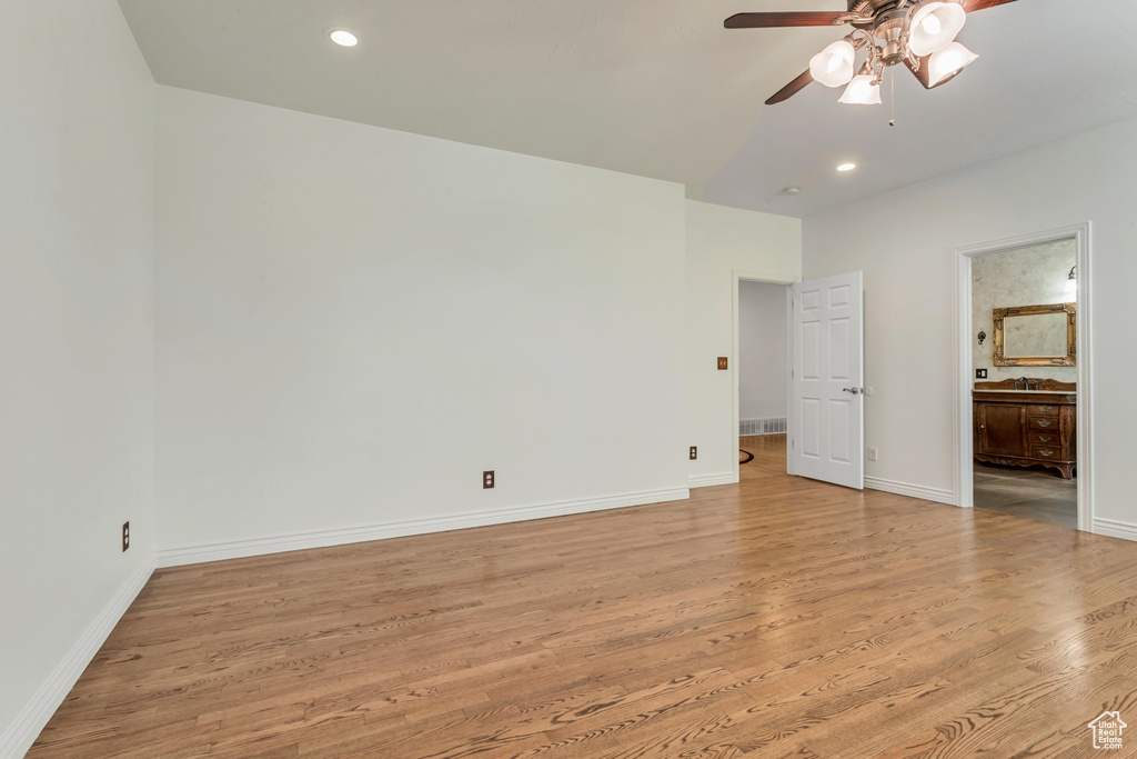 Unfurnished bedroom with ensuite bath, ceiling fan, and light hardwood / wood-style flooring
