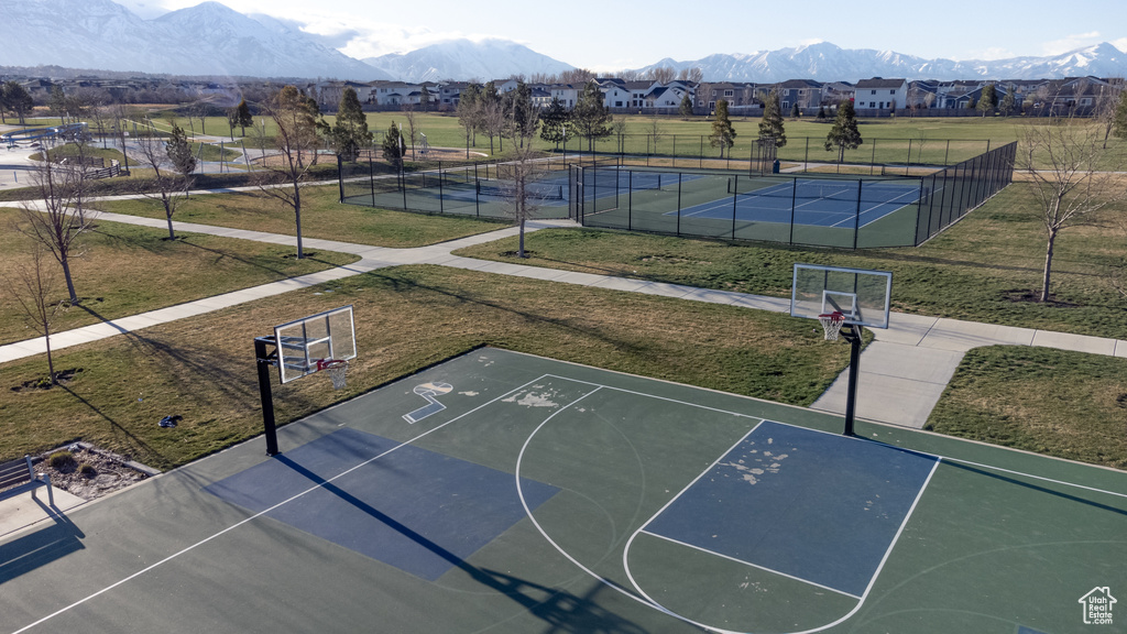 View of basketball court with a mountain view, tennis court, and a yard