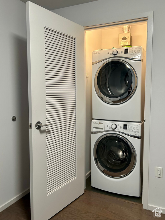 Clothes washing area with stacked washer / dryer and dark wood-type flooring