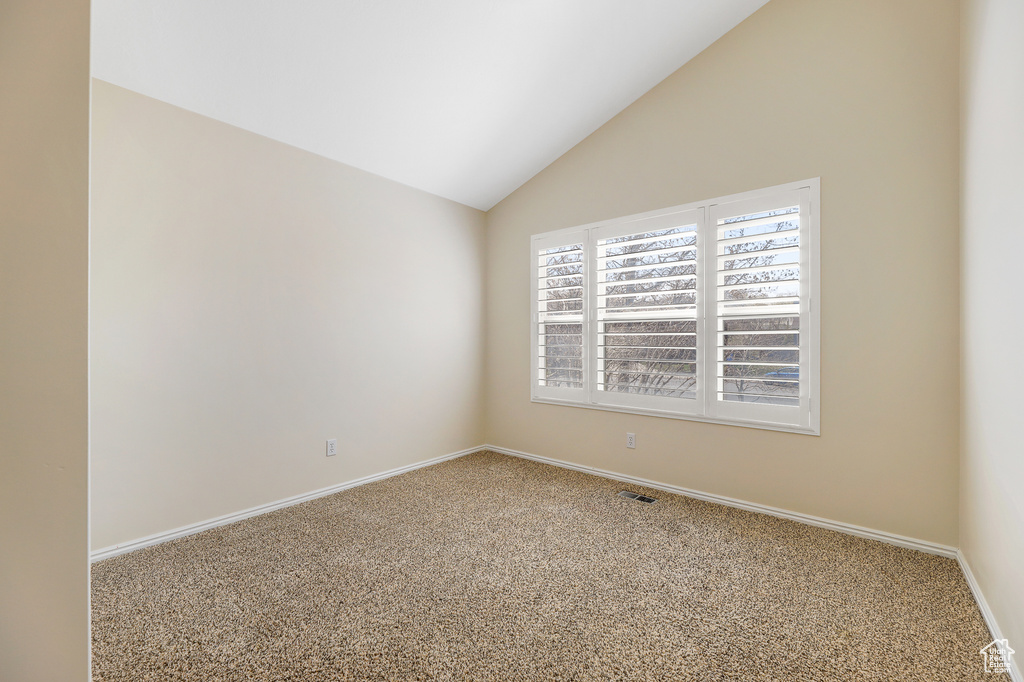 Spare room with light carpet and lofted ceiling