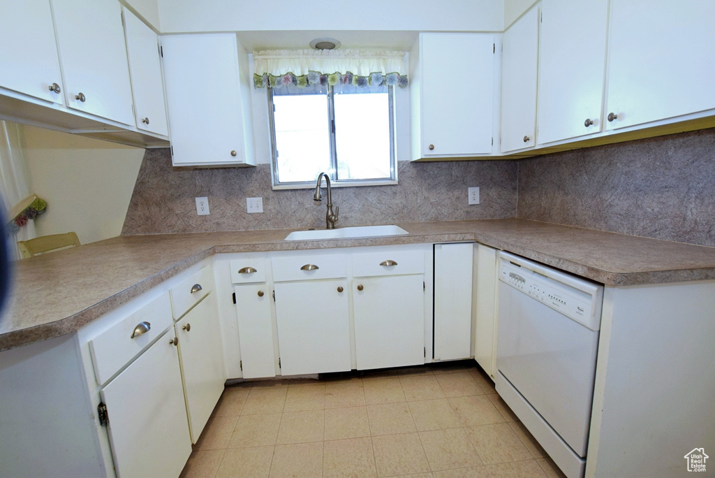Kitchen with dishwasher, light tile floors, sink, tasteful backsplash, and white cabinetry