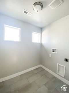 Washroom featuring electric dryer hookup, tile floors, washer hookup, and a wealth of natural light