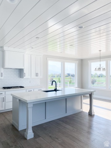 Kitchen with white cabinets, pendant lighting, and dark hardwood / wood-style floors