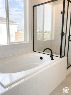 Bathroom featuring tile floors and tiled bath