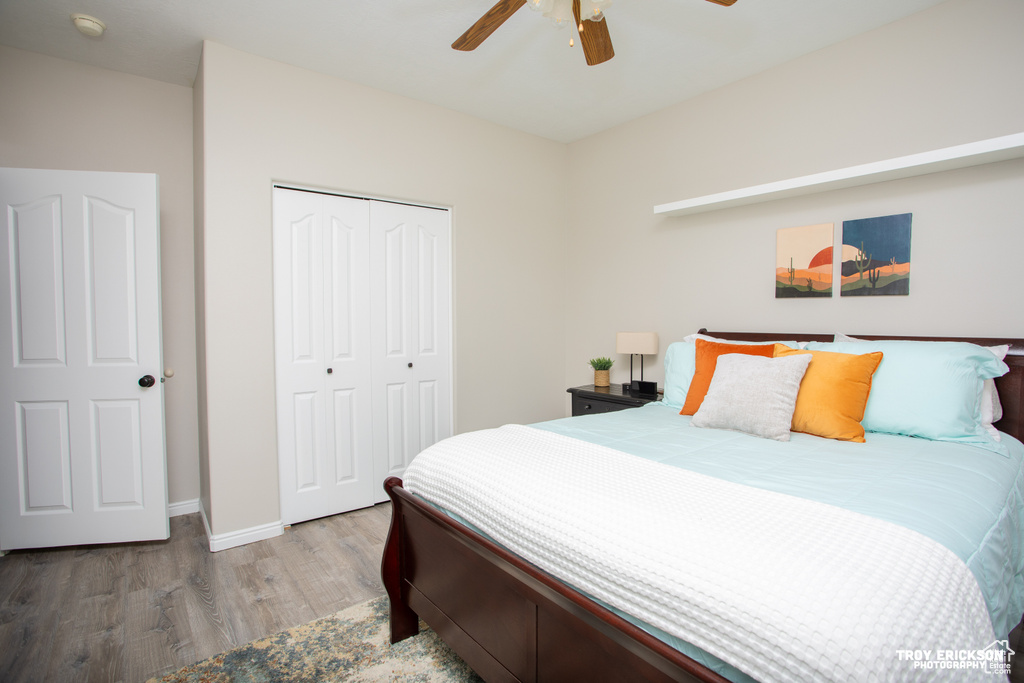 Bedroom with a closet, hardwood / wood-style floors, and ceiling fan