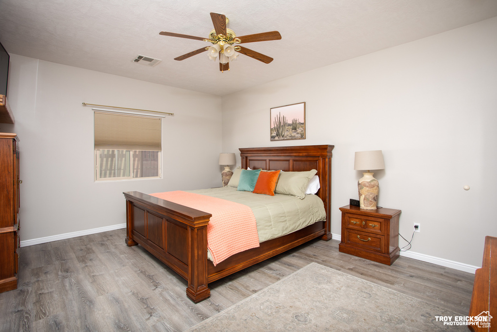 Bedroom with hardwood / wood-style floors and ceiling fan