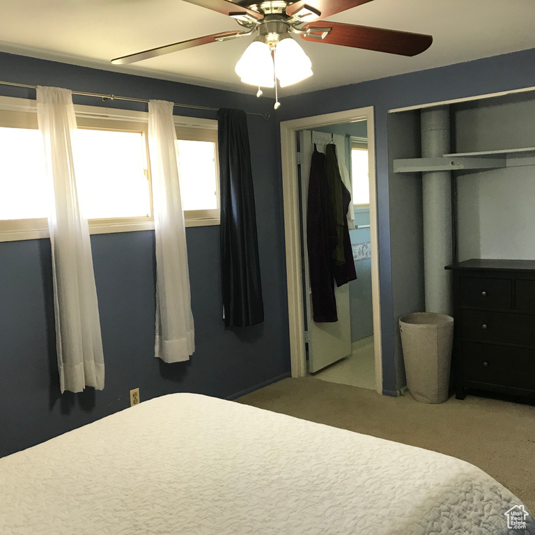 Carpeted bedroom featuring ceiling fan and two closets