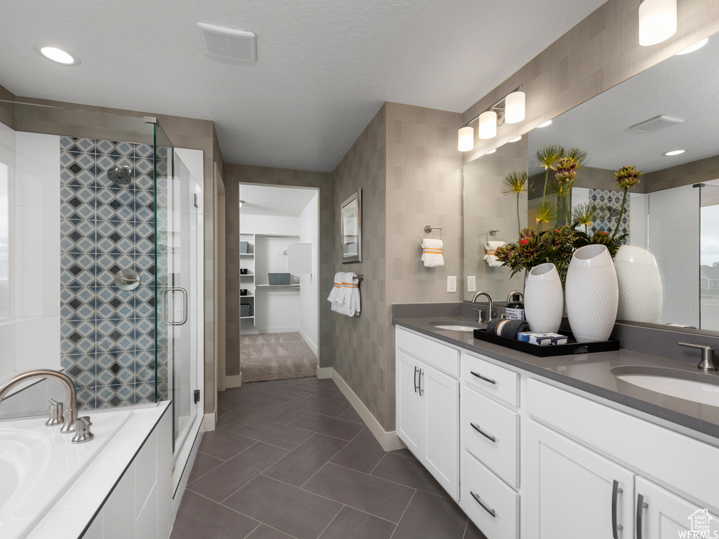 Bathroom with large vanity, dual sinks, separate shower and tub, and tile floors