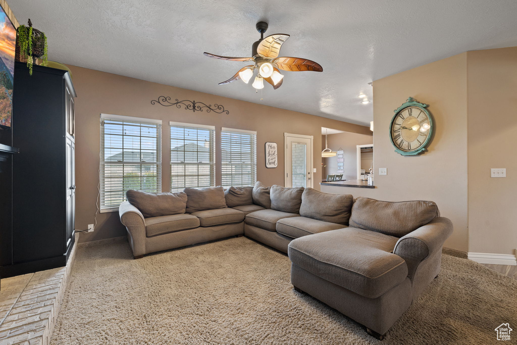Living room with a textured ceiling and ceiling fan