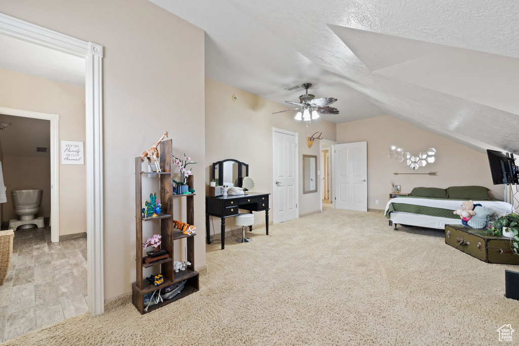 Interior space featuring light carpet, a textured ceiling, lofted ceiling, and ceiling fan