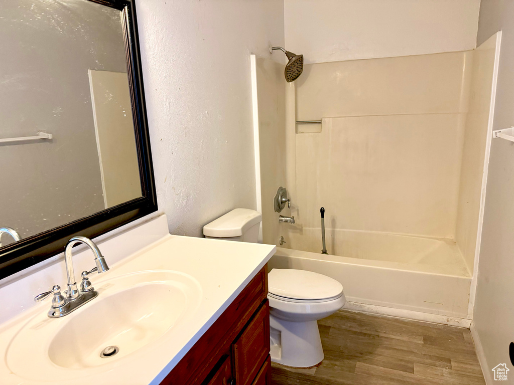 Full bathroom with shower / bathtub combination, vanity, toilet, and hardwood / wood-style floors