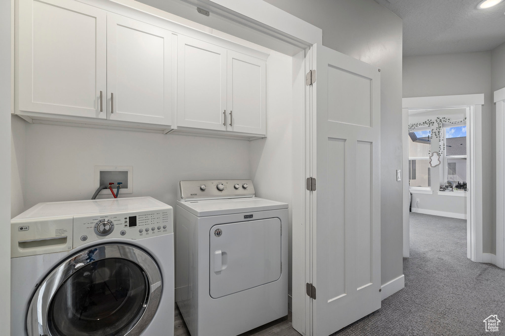 Laundry area with hookup for a washing machine, washer and clothes dryer, carpet, and cabinets