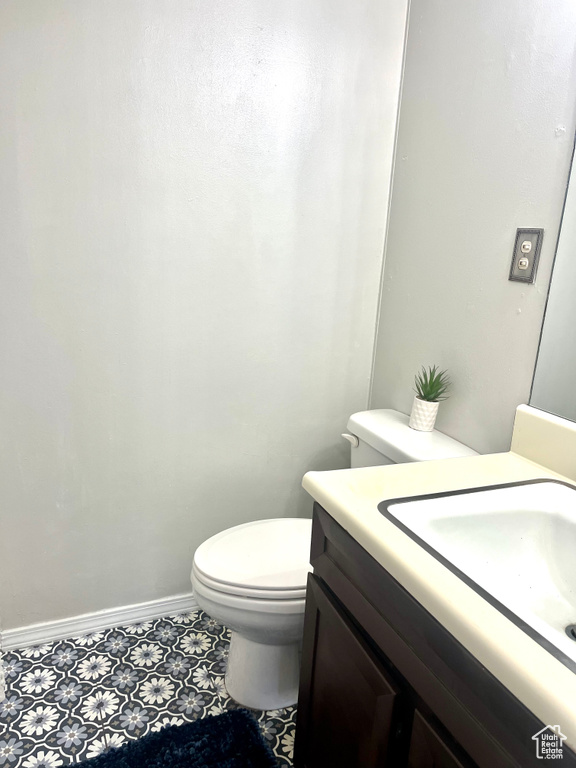 Bathroom featuring toilet, tile floors, and vanity