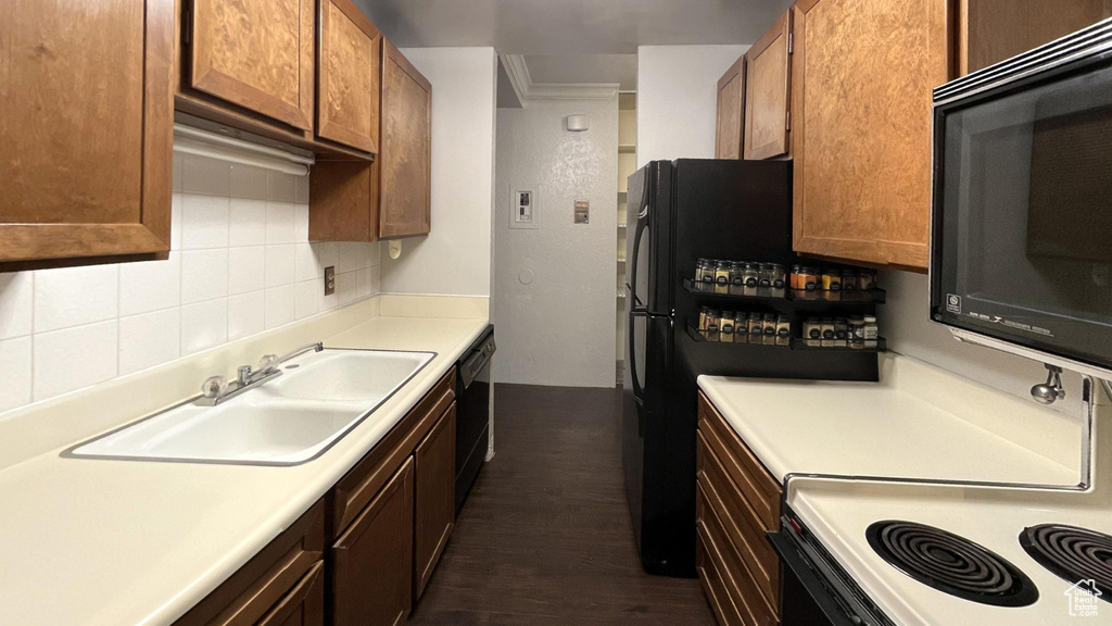 Kitchen with backsplash, dark hardwood / wood-style flooring, and sink