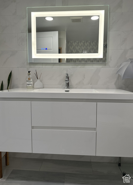Bathroom featuring tile walls, backsplash, tile flooring, and vanity