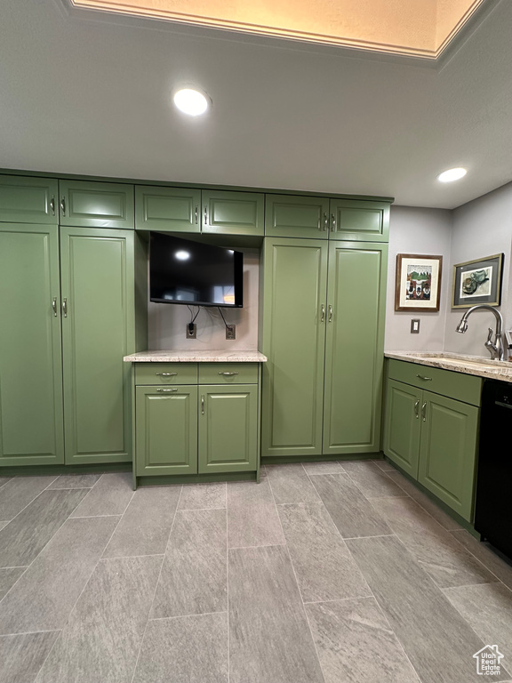 Kitchen featuring green cabinets, sink, and light tile flooring