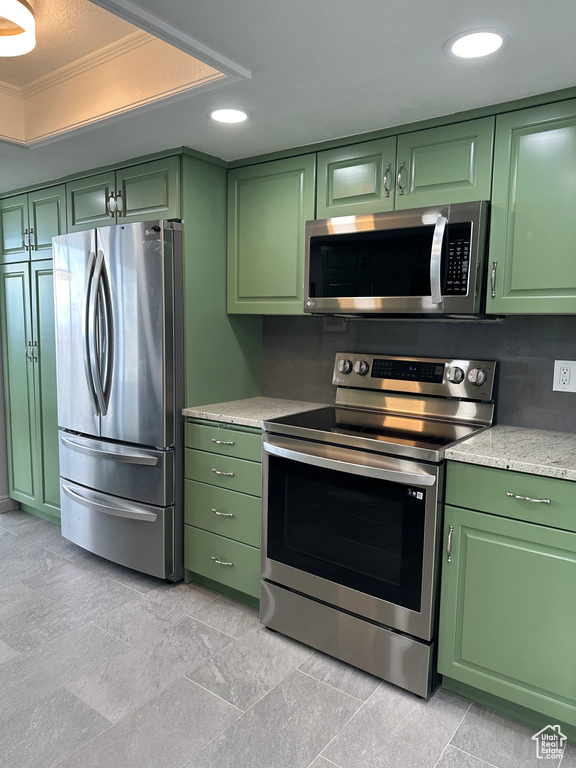 Kitchen with crown molding, green cabinets, and stainless steel appliances