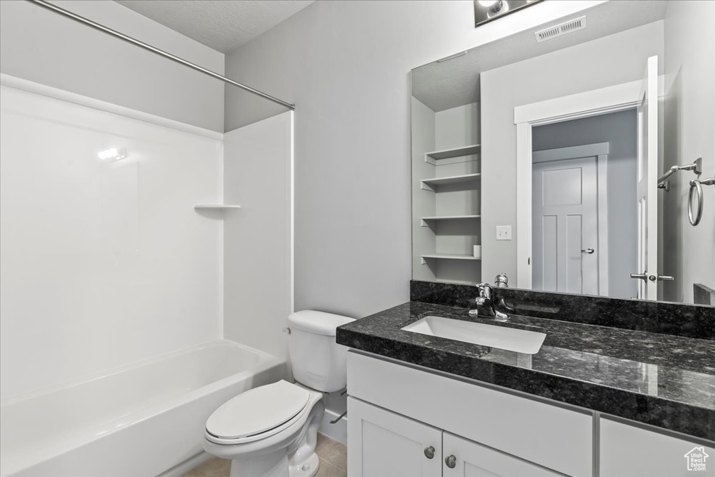 Full bathroom with bathtub / shower combination, tile flooring, oversized vanity, and toilet