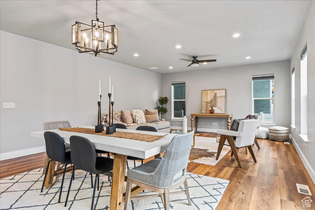Dining area featuring ceiling fan with notable chandelier and light hardwood / wood-style flooring