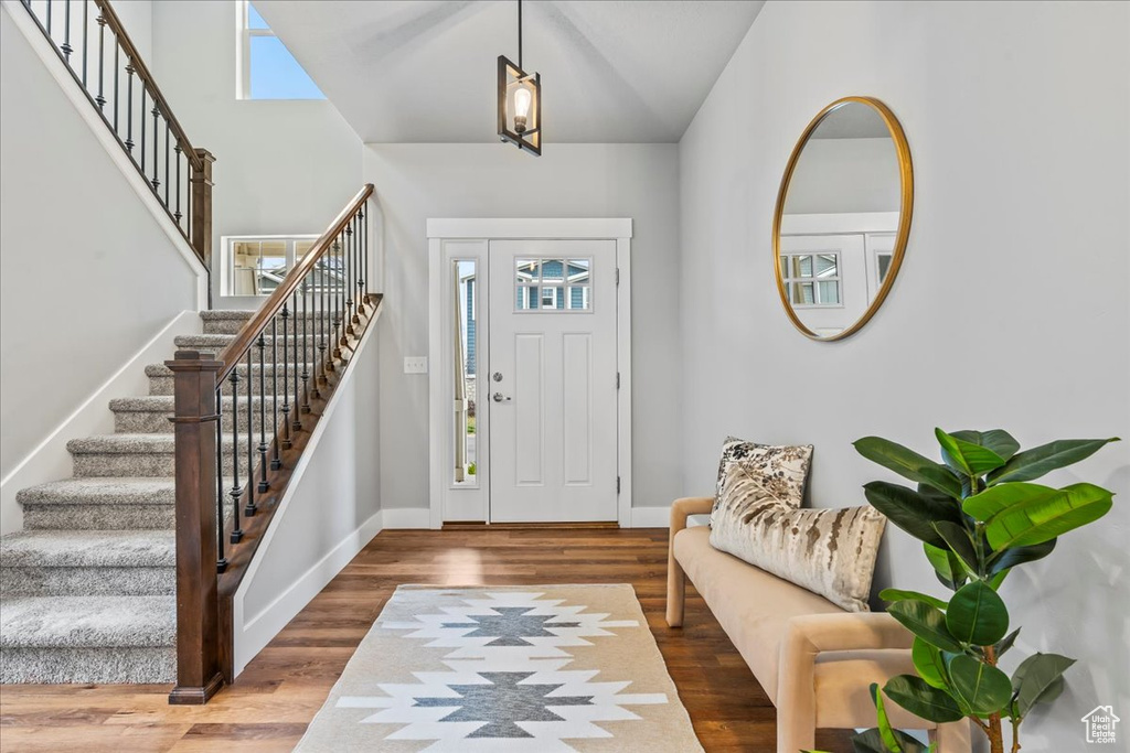 Entryway with high vaulted ceiling and dark hardwood / wood-style floors