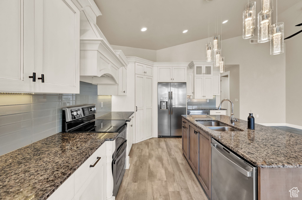 Kitchen featuring appliances with stainless steel finishes, tasteful backsplash, and white cabinetry