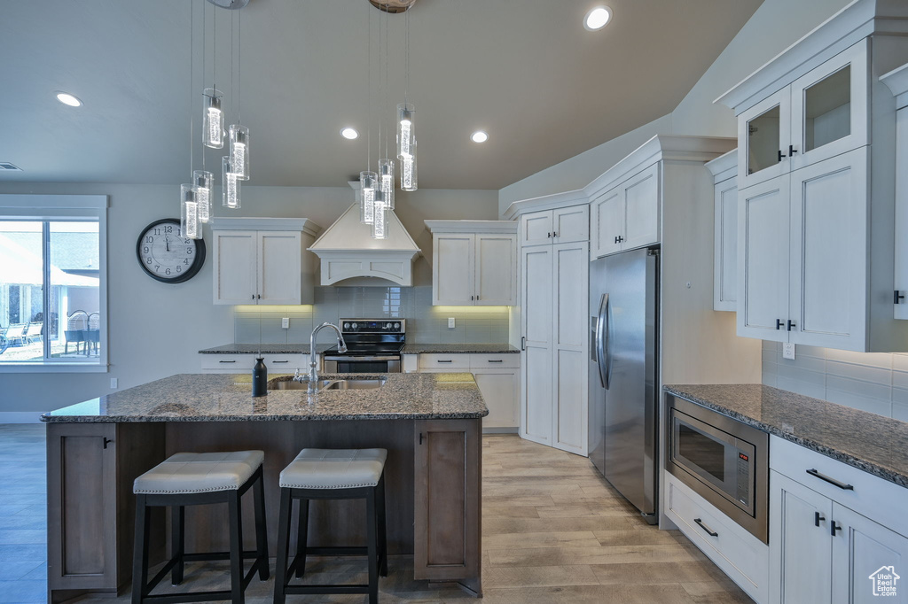 Kitchen with tasteful backsplash, white cabinets, and stainless steel appliances