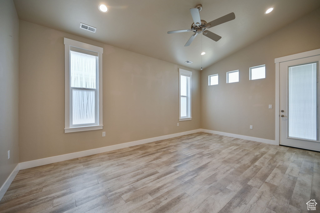 Unfurnished room featuring ceiling fan, lofted ceiling, and light hardwood / wood-style floors
