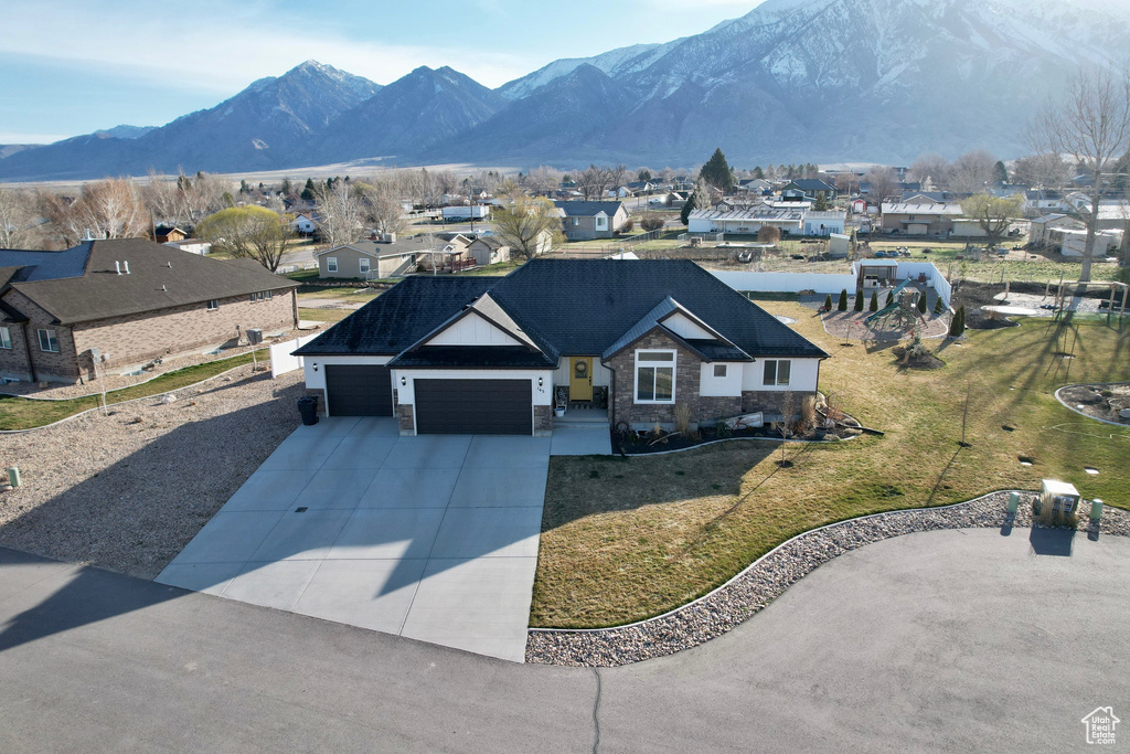 View of front of home featuring a garage, a front yard, and a mountain view