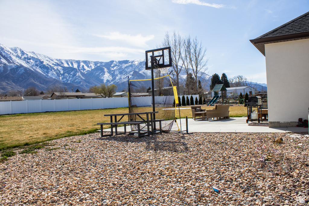 Exterior space with a mountain view, a lawn, and a playground