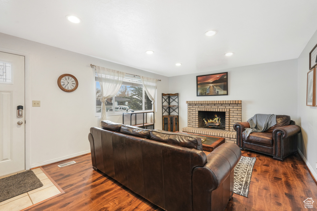 Living room featuring a brick fireplace and dark hardwood / wood-style flooring