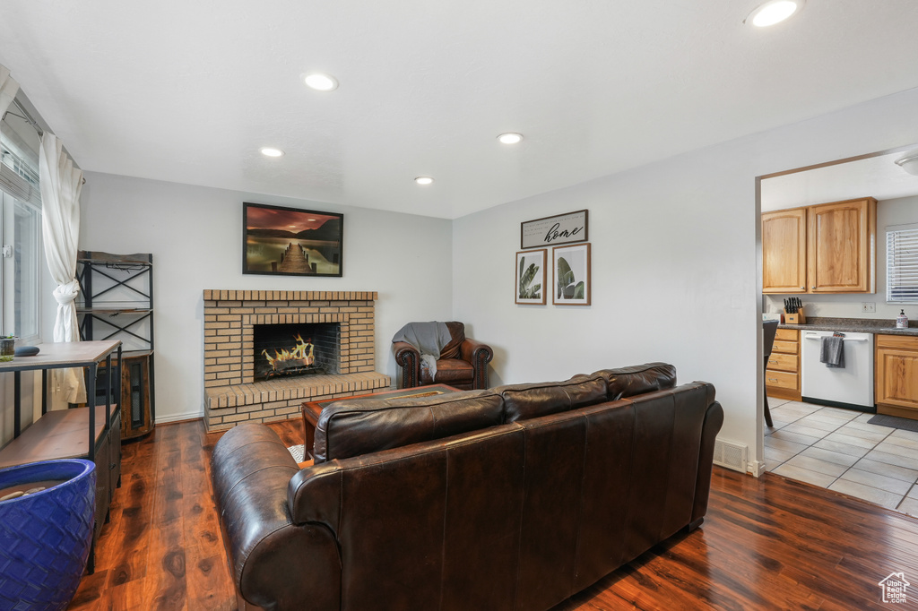 Living room with a healthy amount of sunlight, tile flooring, and a brick fireplace