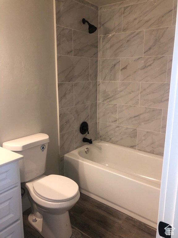 Full bathroom featuring hardwood / wood-style floors, vanity, toilet, and tiled shower / bath
