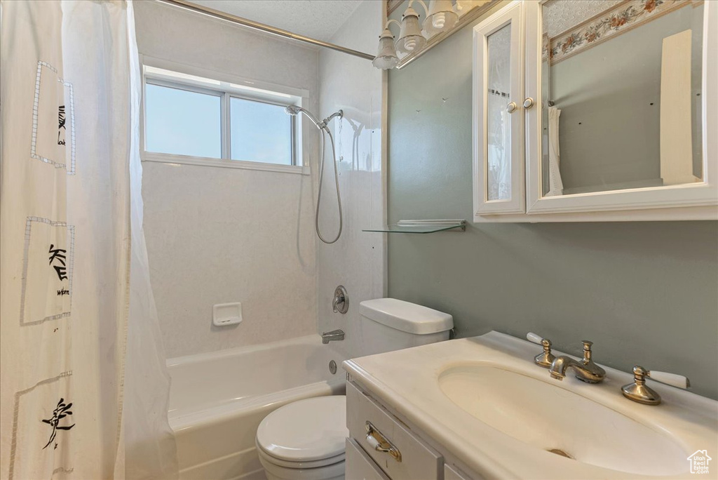 Full bathroom with shower / bath combo, oversized vanity, and toilet