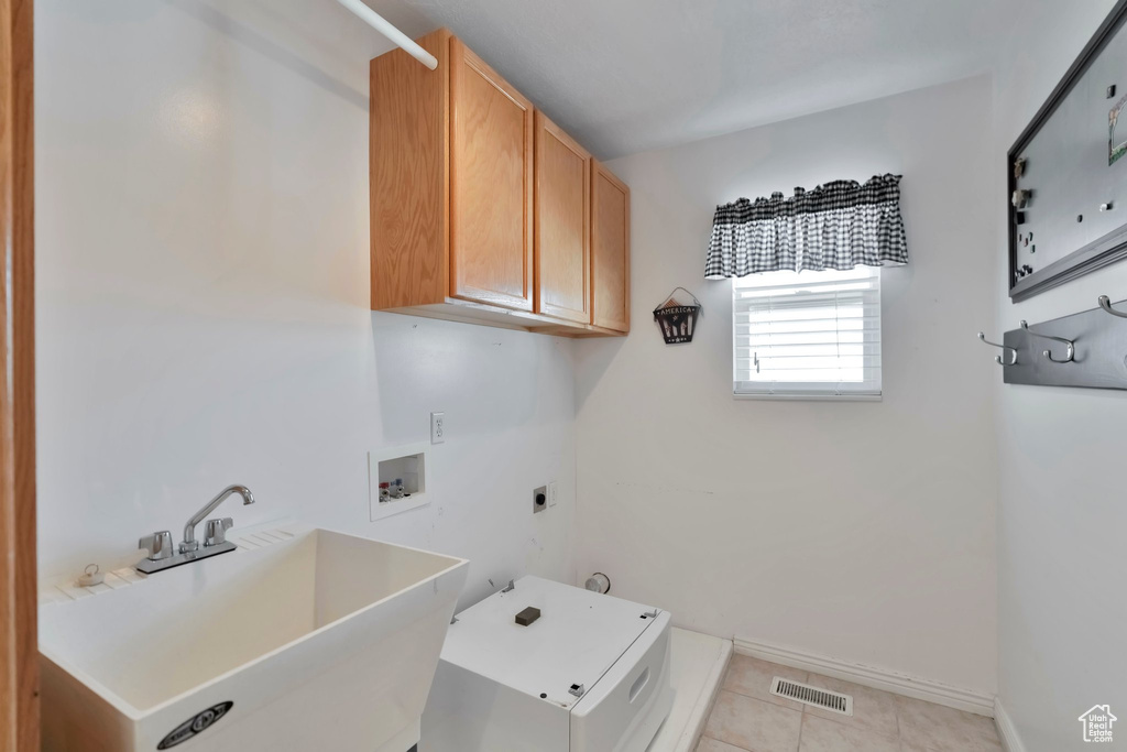 Laundry room with hookup for a washing machine, sink, electric dryer hookup, cabinets, and light tile floors