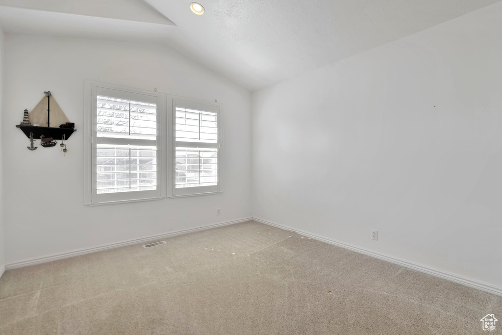 Spare room with lofted ceiling and light colored carpet