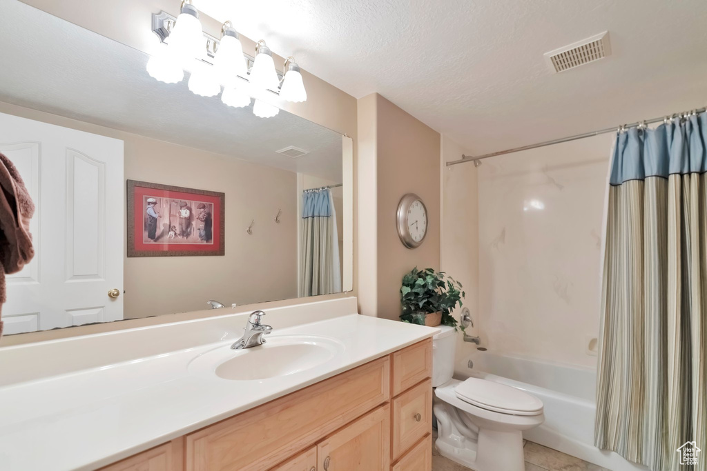 Full bathroom featuring tile floors, vanity, shower / tub combo with curtain, and toilet
